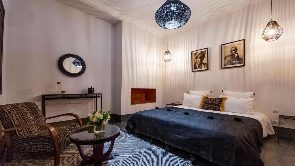 une chambre avec un lit, une chaise et une table dans l'établissement RIAD 48 & SPA, à Marrakech
