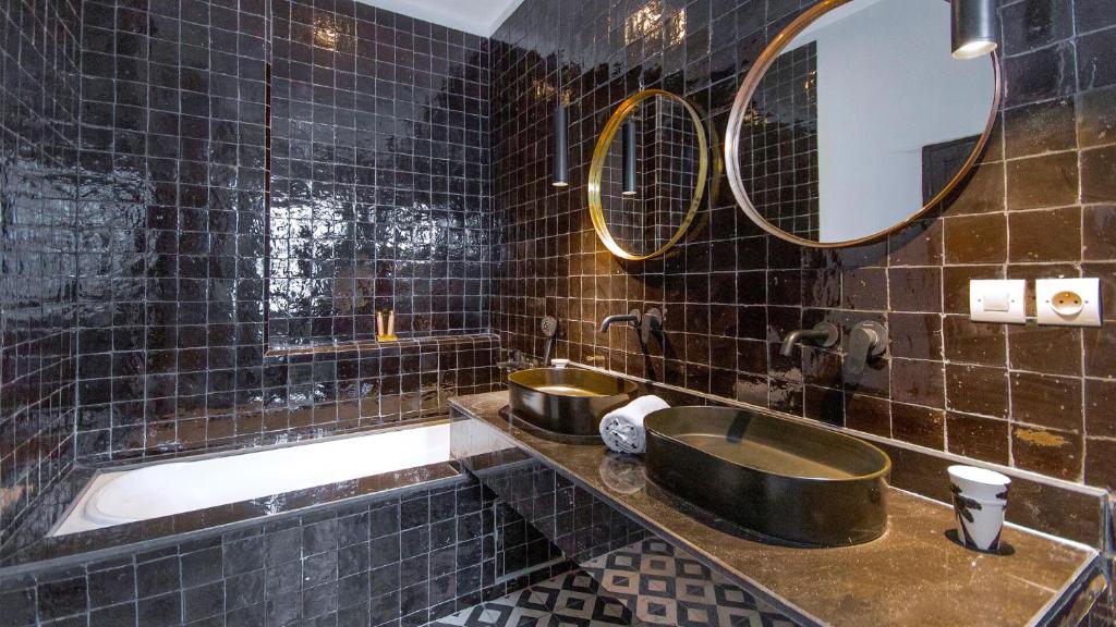 La salle de bains est pourvue de carrelage noir, d'un lavabo et de deux miroirs. dans l'établissement RIAD 48 & SPA, à Marrakech 37 autres photos