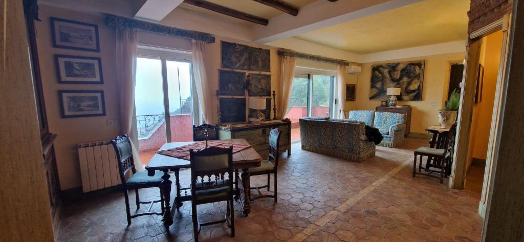 une salle à manger avec une table et des chaises et un salon dans l'établissement villa favoloso, à Taormine