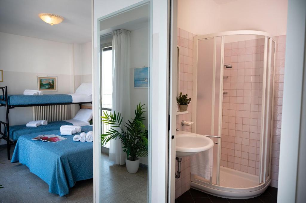 une salle de bain avec un lavabo et une chambre avec un lit dans l'établissement Hotel Selene - Vista Mare, à Riccione