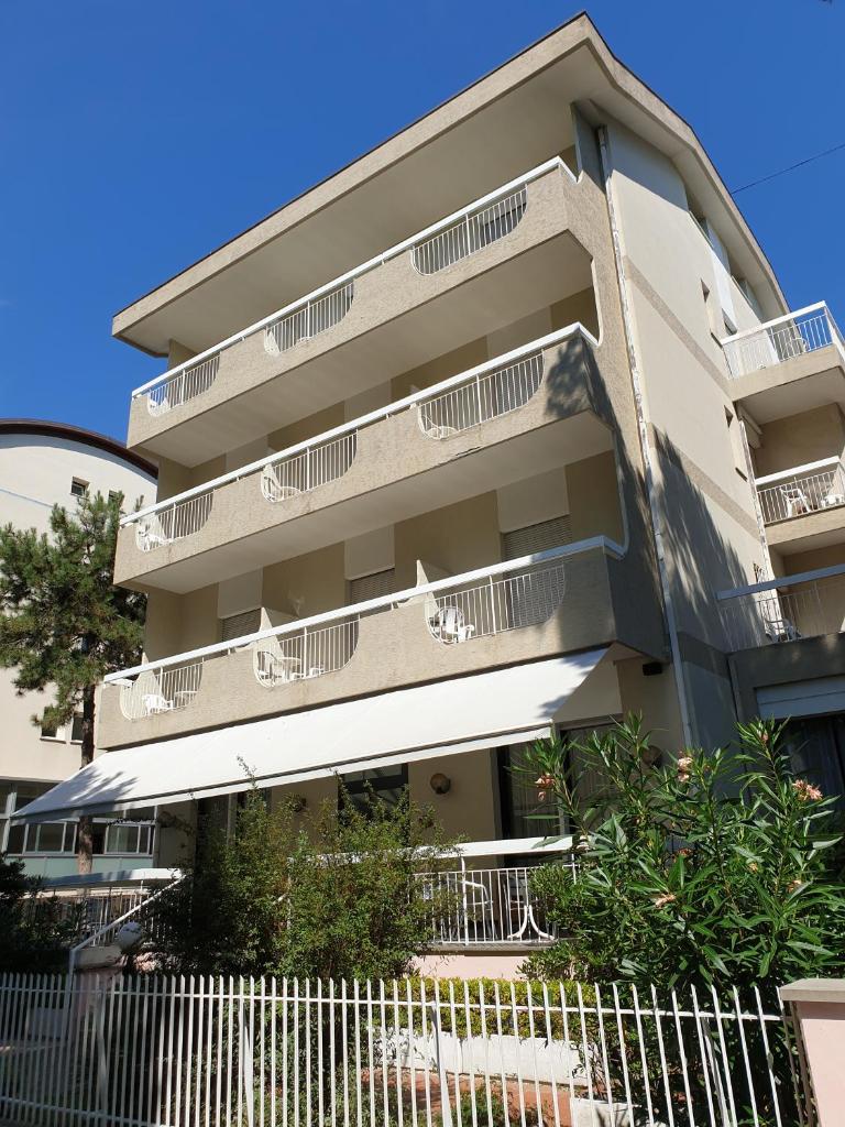 un bâtiment avec des balcons et une clôture devant dans l'établissement B&B Domus Mea, à Cesenatico