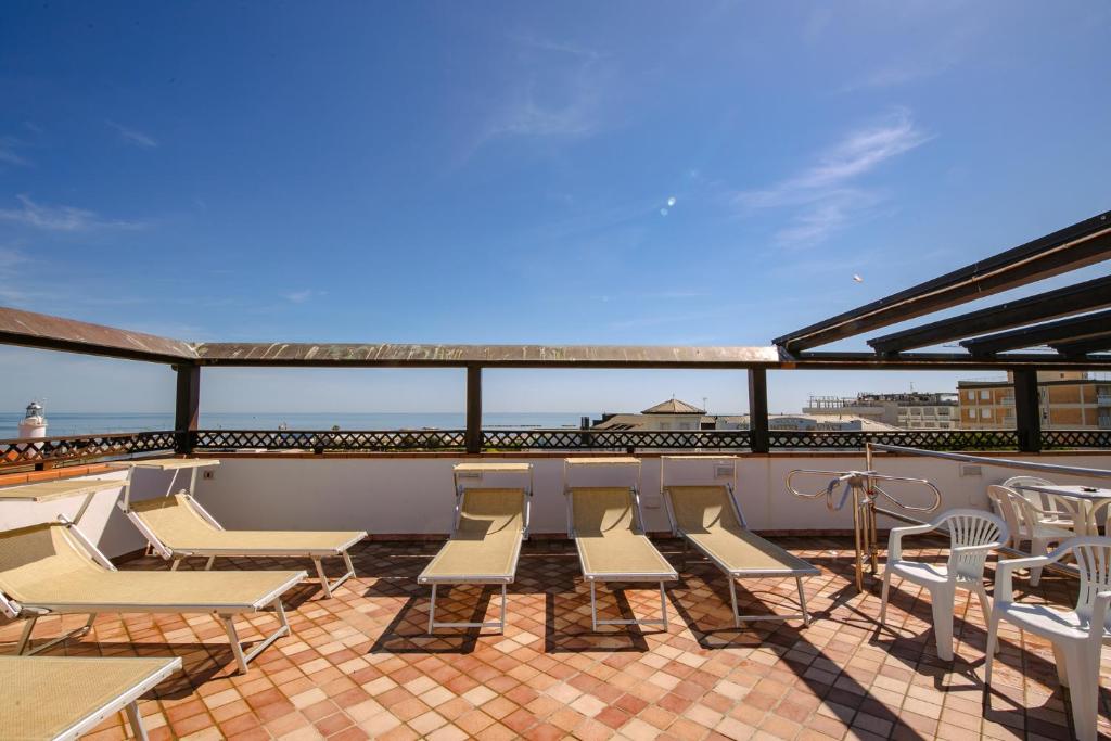un ensemble de chaises et de tables sur un balcon dans l'établissement B&B Domus Mea, à Cesenatico