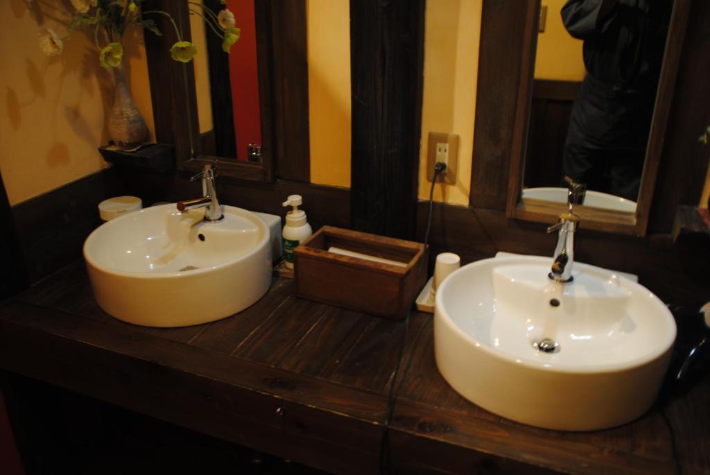 deux lavabos sur un comptoir en bois dans une salle de bain dans l'établissement Oyado Ichifuji, à Nikkō