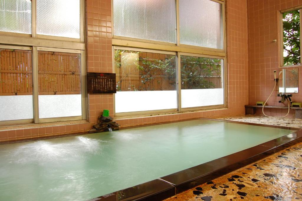 - une piscine d'eau dans une chambre avec fenêtres dans l'établissement Wakanoyu, à Chikuma