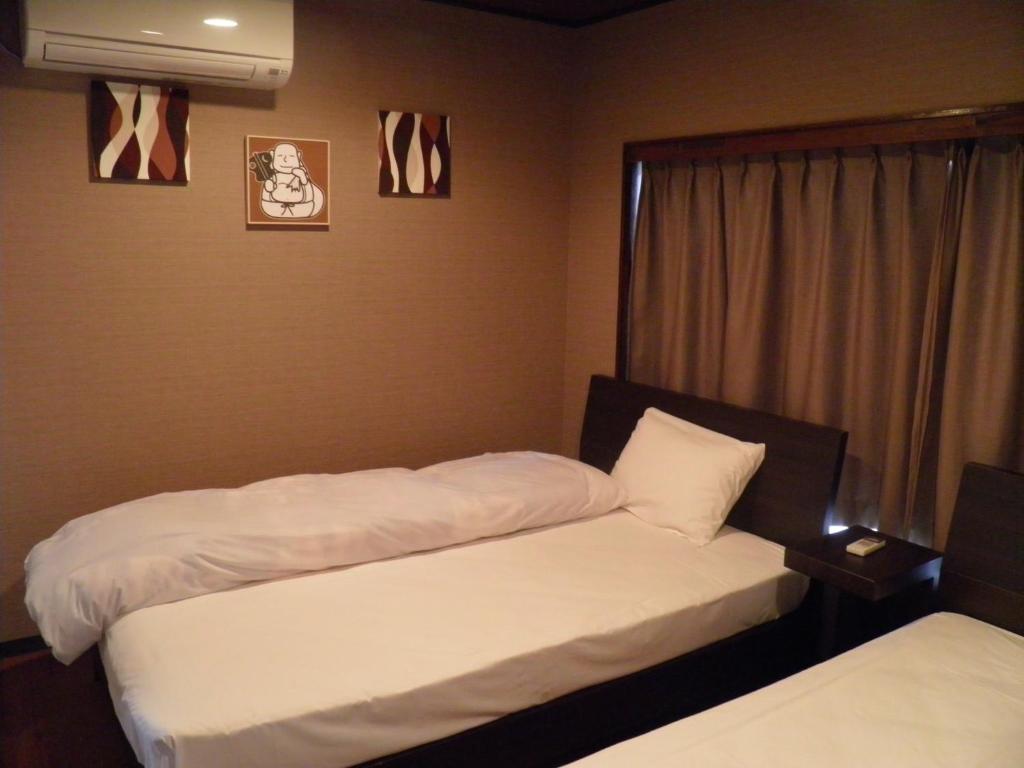 une chambre avec deux lits et une fenêtre dans l'établissement Wakanoyu, à Chikuma