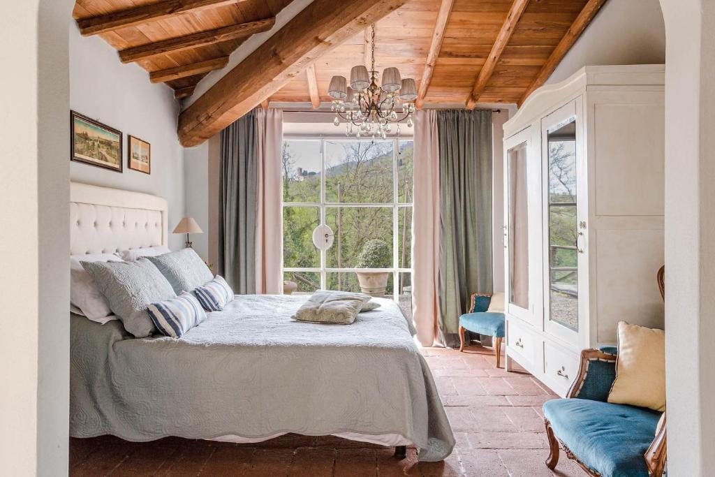une chambre avec un lit et une grande fenêtre dans l'établissement Il Palagio villa, à Capannori