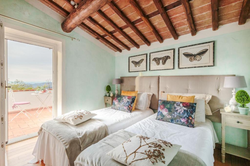 deux lits dans une chambre avec balcon dans l'établissement Rondini, Farmhouse with pool, à Chiatri