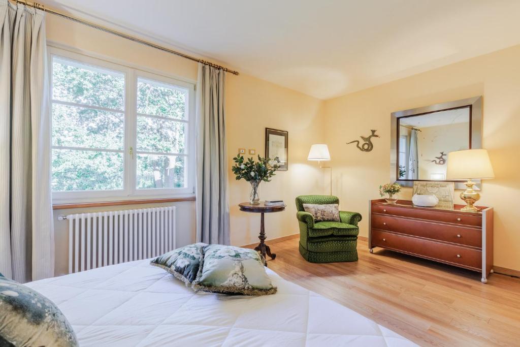 une chambre avec un lit, une commode et une fenêtre dans l'établissement Villa Bassotta, a Charming Cottage, à Lucques
