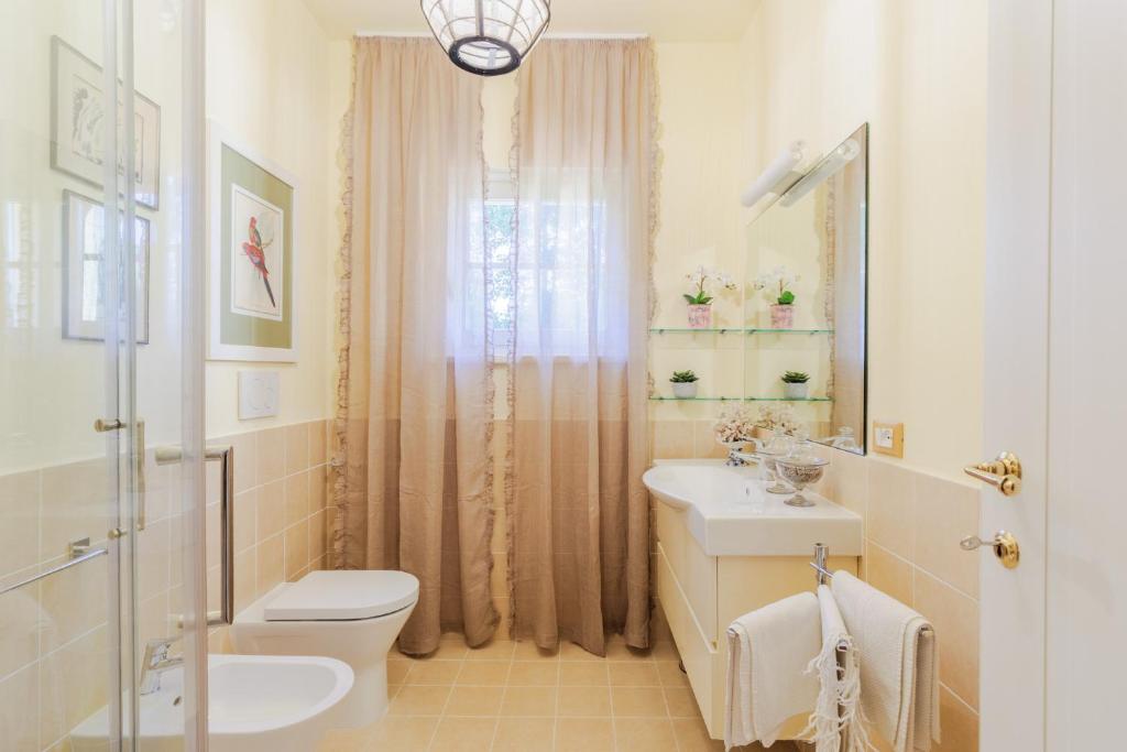 une salle de bain avec toilettes, lavabo et douche dans l'établissement Villa Bassotta, a Charming Cottage, à Lucques