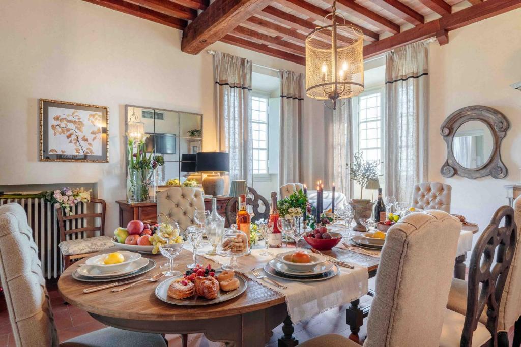 une salle à manger avec une table sur laquelle se trouve de la nourriture dans l'établissement Villa Il Castello, à San Quirico di Moriano