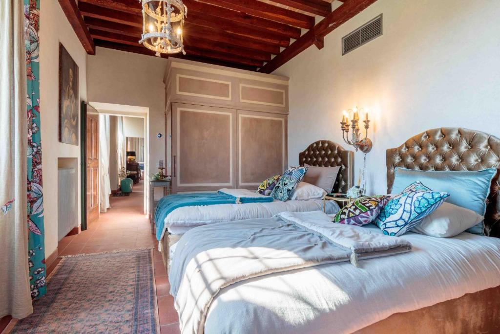 une chambre avec deux lits et un lustre dans l'établissement Villa Il Castello, à San Quirico di Moriano 183 autres photos