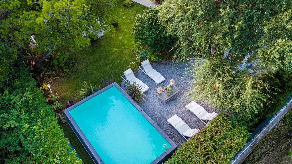 - une vue sur la piscine dotée de chaises longues et de sidx sidx dans l'établissement Villa Gianna, the Secret Interior Designer's Private Retreat with Pool, à San Piero in Campo