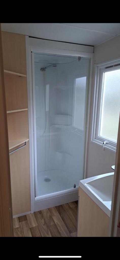 une douche en verre dans une cuisine avec une fenêtre dans l'établissement Mobil-home Saint-Chéron 91530 Camping Parc des roches, à Mirgaudon