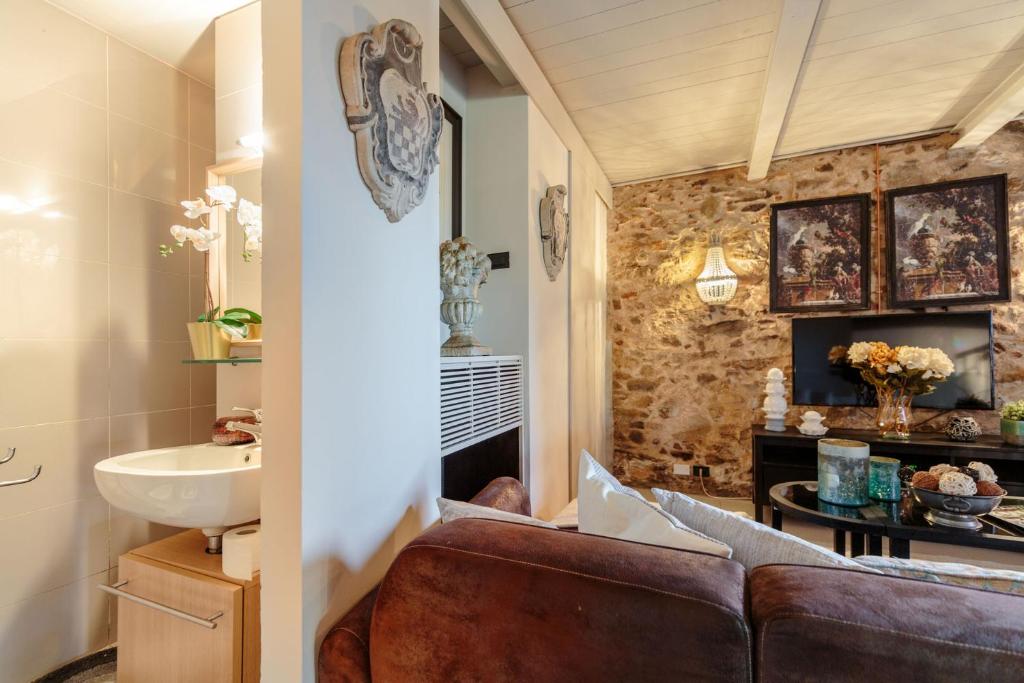 - un salon avec un canapé et un lavabo dans l'établissement Villa Catia Farmhouse, Three Luxury Bedrooms, a Jacuzzi Pool and a Dream-Like Getaway Experience, à Capannori