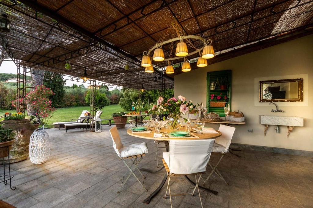 d'une terrasse avec une table et des chaises et un plafond. dans l'établissement Cottage Nanni, Romantic and Luxury with Pool, à Pescia