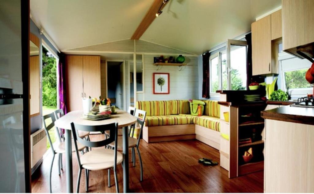 une cuisine et un salon avec une table et un canapé dans l'établissement Camping écovillage Soleil du Pibeste, à Agos-Vidalos