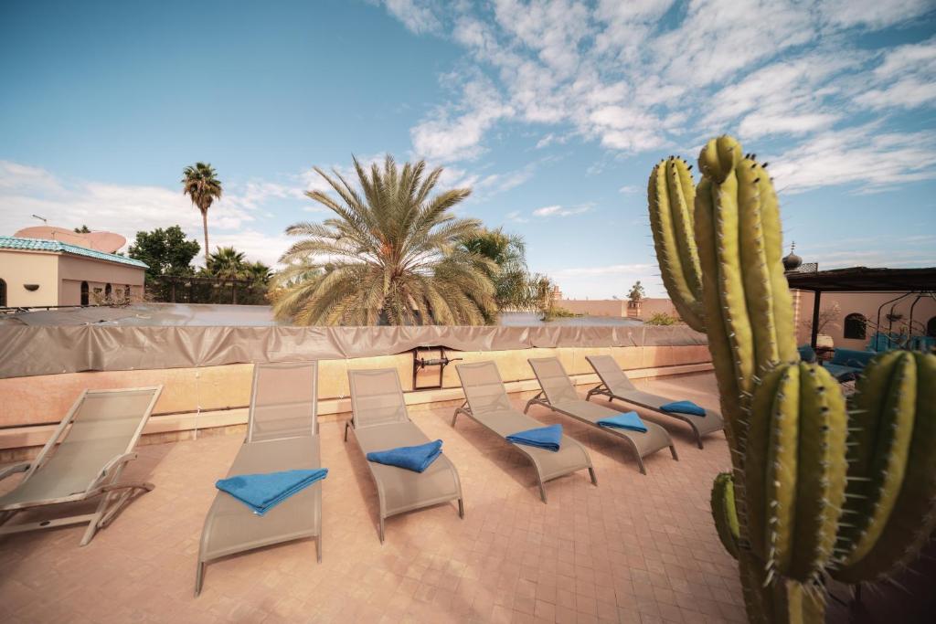 un groupe de chaises et un cactus sur une terrasse dans l'établissement Demeures d'Orient Riad & Spa, à Marrakech