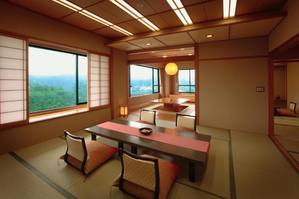 une pièce avec une table, des chaises et des fenêtres dans l'établissement Sansatei, à Zao