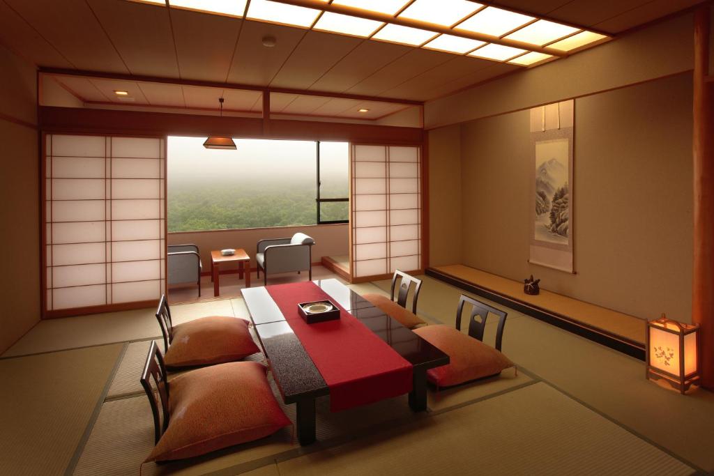 une pièce avec une table, des chaises et une fenêtre dans l'établissement Sansatei, à Zao