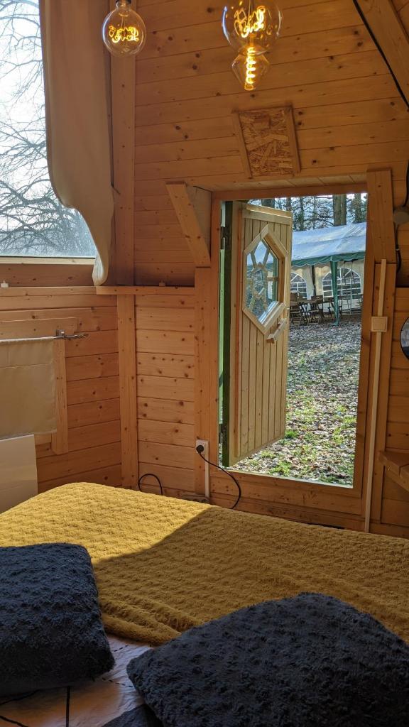 une chambre avec un lit dans une cabane en rondins dans l'établissement Gîte de groupe nature proche Nancy, à Marbache