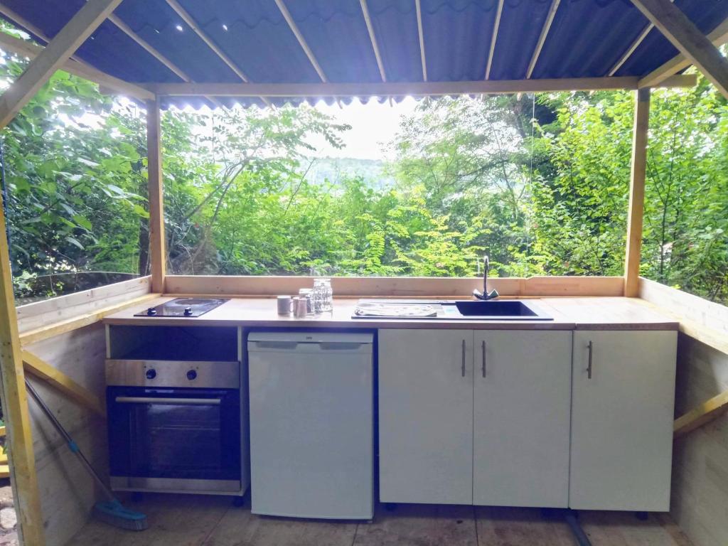 une cuisine extérieure avec un évier et une fenêtre dans l'établissement Gîte de groupe nature proche Nancy, à Marbache