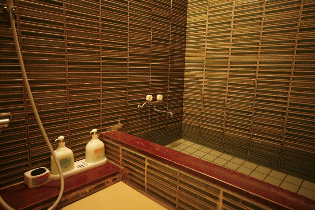 La salle de bains est pourvue d'une cabine de douche en verre. dans l'établissement Sennennoyu Koman, à Toyooka