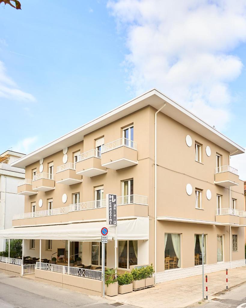 un grand immeuble d'appartements dans une rue dans l'établissement Hotel Villa Perazzini, à Rimini