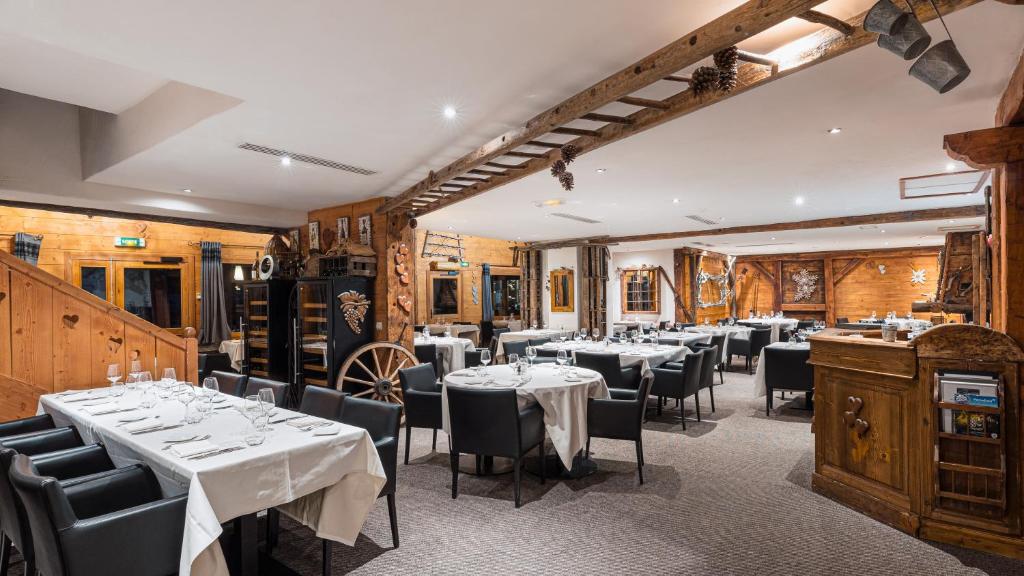 un restaurant avec des tables et des chaises dans une salle dans l'établissement Résidence Carlina by Les Etincelles, à Belle Plagne