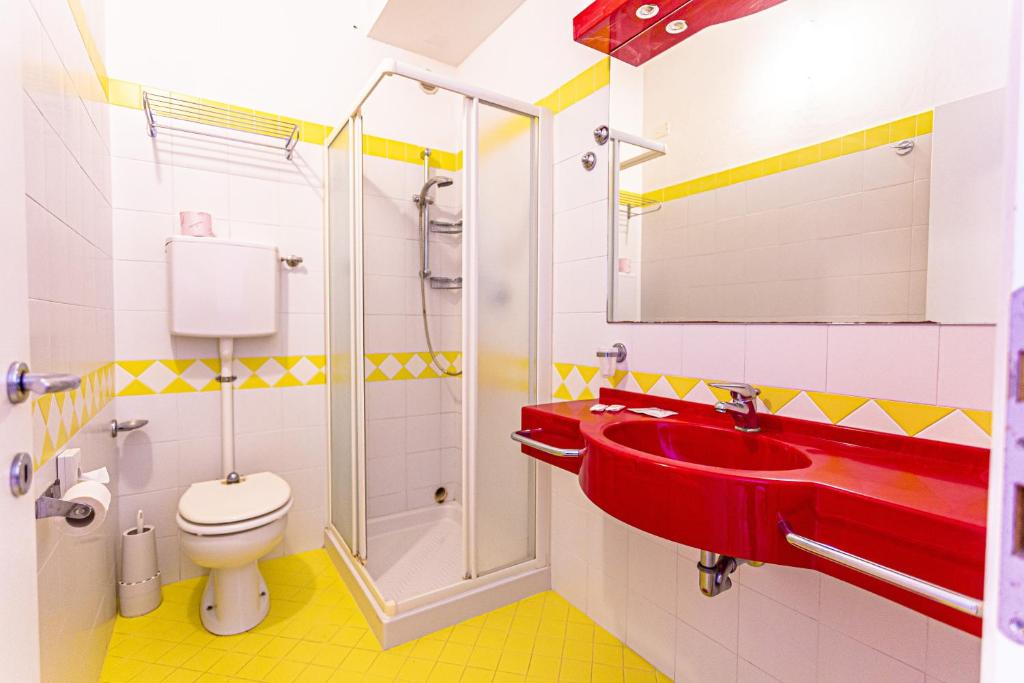 La salle de bains est pourvue d'un lavabo rouge et de toilettes. dans l'établissement Hotel Continental, à Bellaria-Igea Marina 33 autres photos