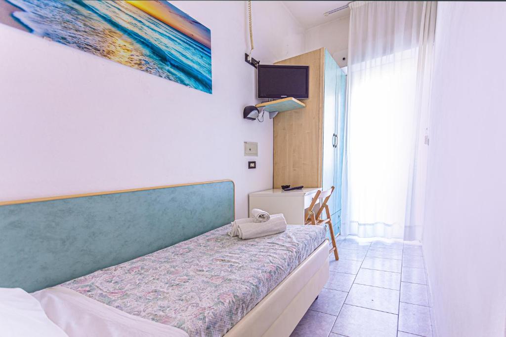 une chambre avec un lit et un tableau au mur dans l'établissement Hotel Continental, à Bellaria-Igea Marina
