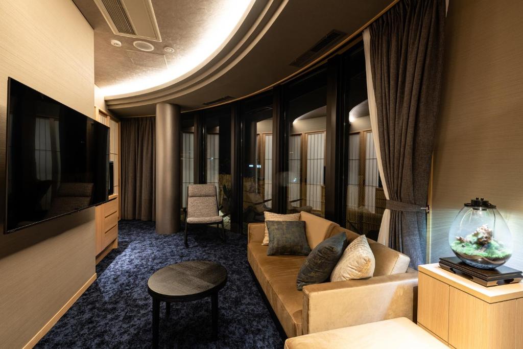 un salon avec un canapé et une télévision dans l'établissement Arima Onsen ShikinoIrodori Hatago, à Kobe