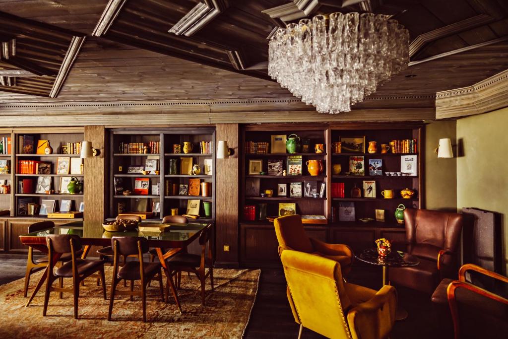 une salle à manger avec une table, des chaises et un lustre dans l'établissement Le Fitz Roy, a Beaumier hotel, à Val Thorens