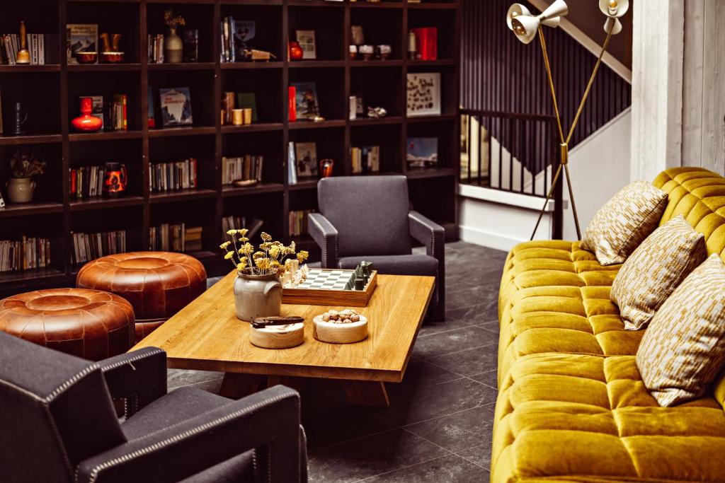 un salon avec un canapé jaune et une table dans l'établissement Le Val Thorens, a Beaumier hotel, à Val Thorens
