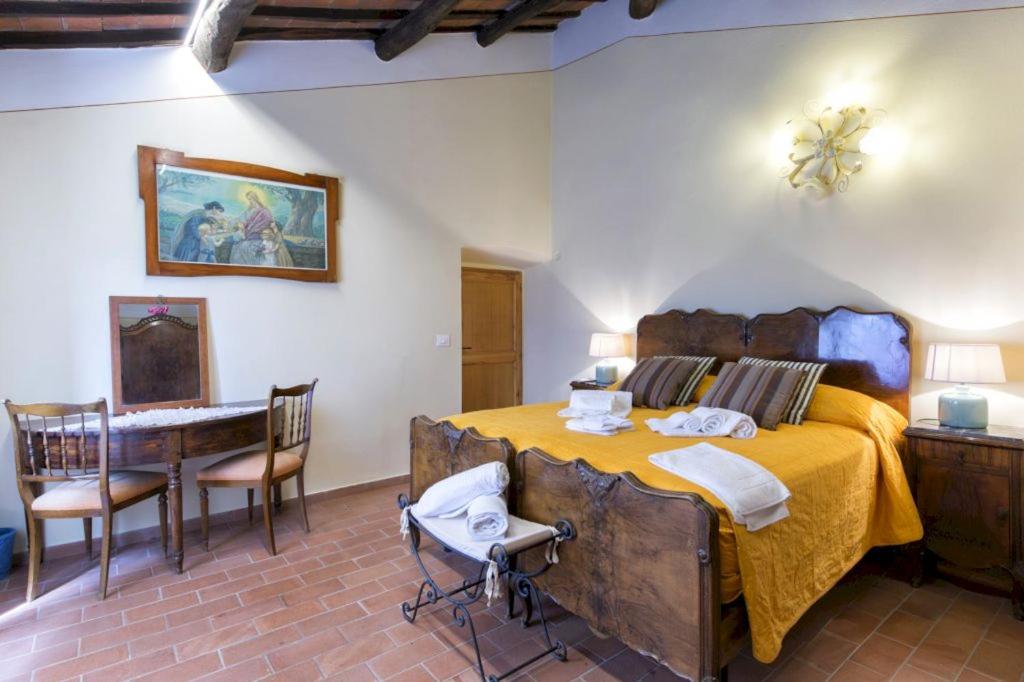 une chambre avec un grand lit et une table et des chaises dans l'établissement La Poventa, à Cortone