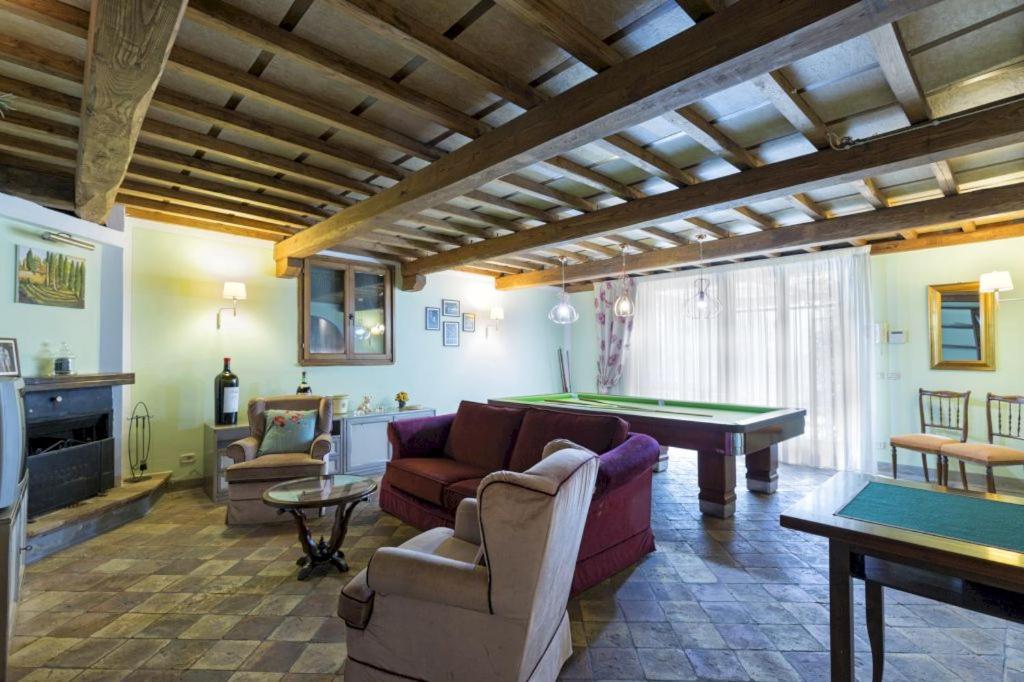 un salon avec des canapés et une table de billard dans l'établissement La Poventa, à Cortone