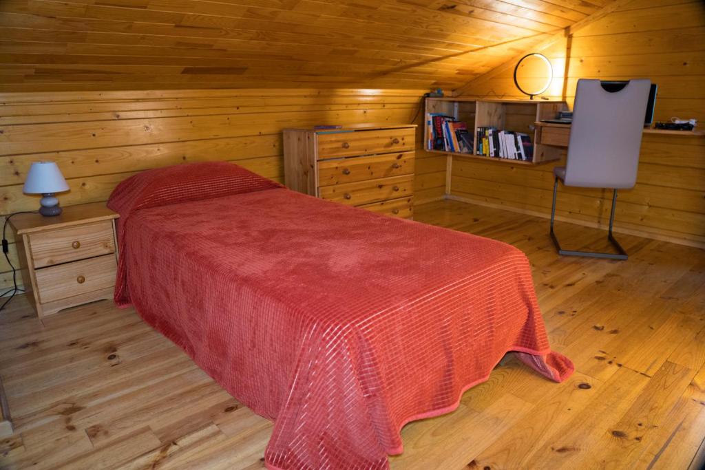 une chambre avec un lit dans une cabane en bois dans l'établissement GITES de Plos Appart CHALET PISCINE SPA, à Anduze