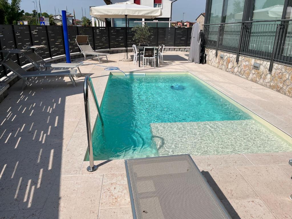 - une piscine avec une table et des chaises à côté dans l'établissement CASA DANZI, à Peschiera del Garda