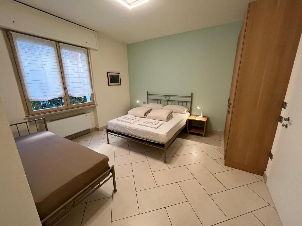 une chambre avec un lit et une table et deux fenêtres dans l'établissement CASA DANZI, à Peschiera del Garda