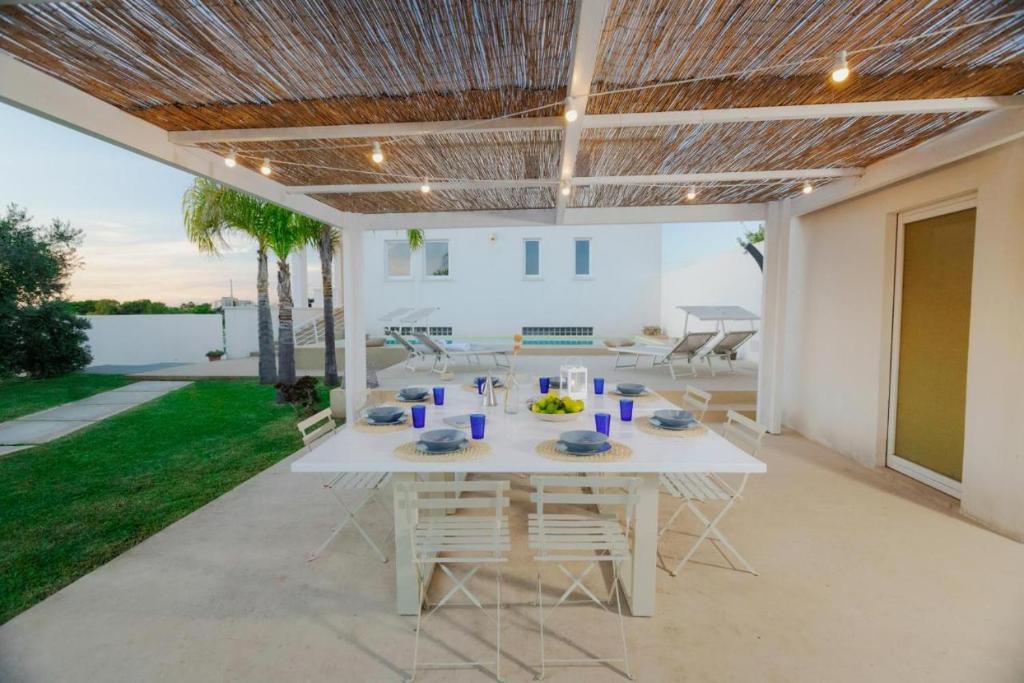 une table blanche et des chaises sur une terrasse dans l'établissement Villa Delia, à Mazara del Vallo