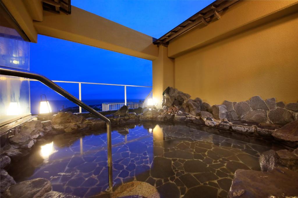 - un bain à remous intérieur dans un bâtiment avec des rochers dans l'établissement Yururi Nishiizu, à Izu