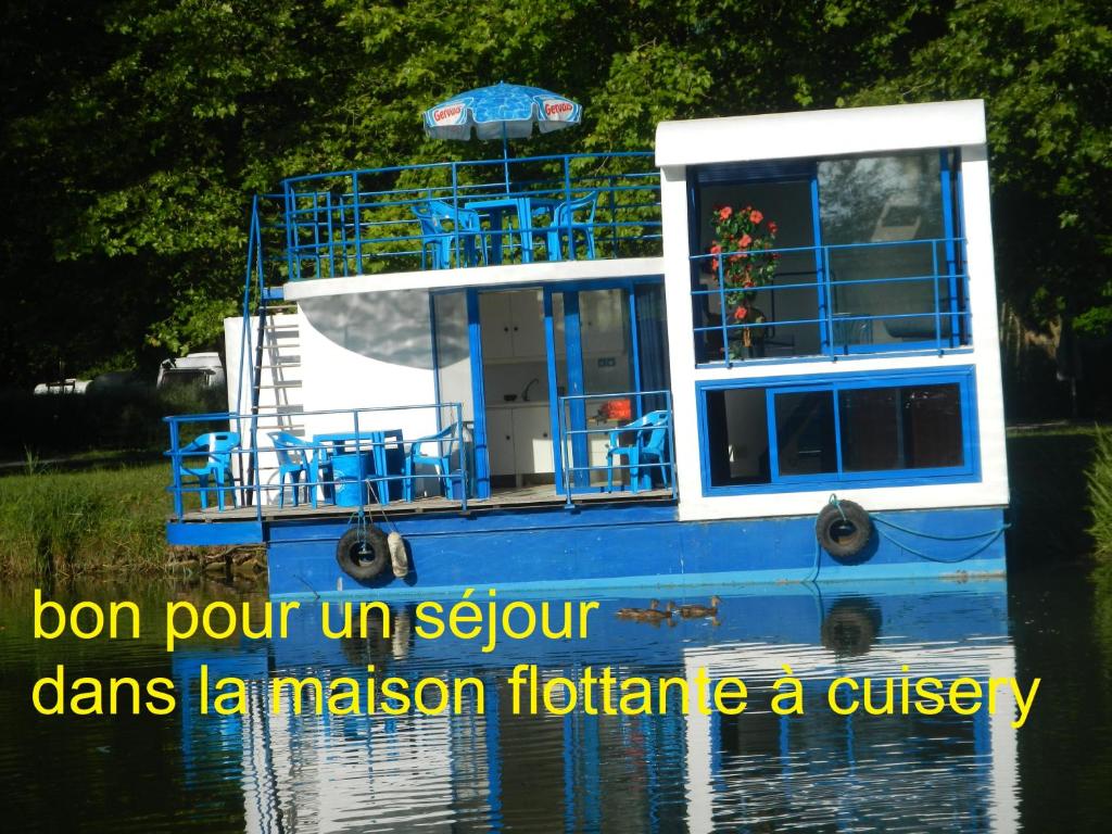 Un bateau bleu dans l'eau avec les mots bon pour un solvant dms la dans l'établissement Maison flottante sur la seille, à Cuisery 3 autres photos