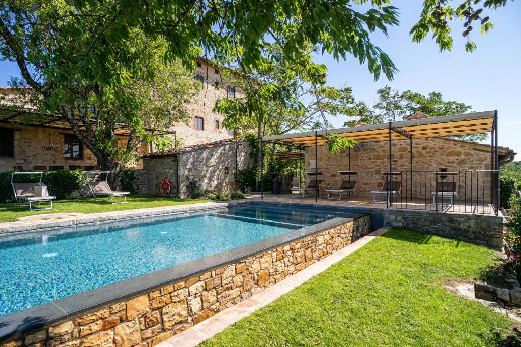- une piscine dans une cour dotée d'un mur en pierre dans l'établissement Casa all'Erta, villa with private pool, à Gaiole in Chianti
