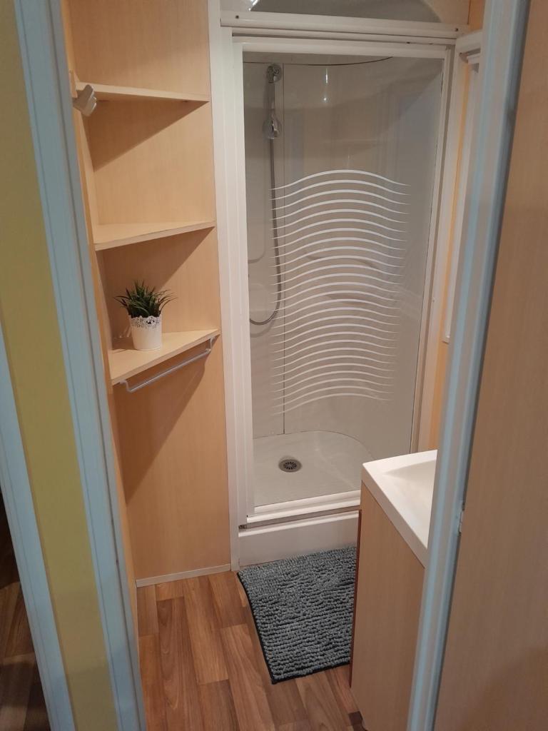 La salle de bains est pourvue d'une douche à l'italienne et d'une cabine de douche en verre. dans l'établissement location mobil-home le parc des roches, à Saint-Chéron