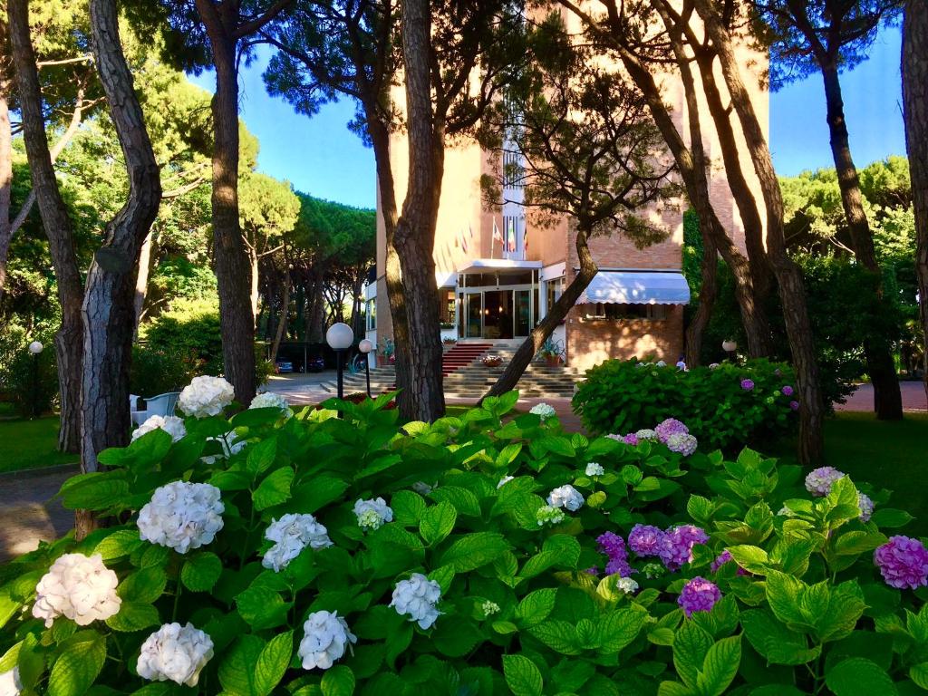 un jardin avec des fleurs devant un immeuble dans l'établissement Hotel Beau Rivage Pineta, à Lido di Jesolo 56 autres photos