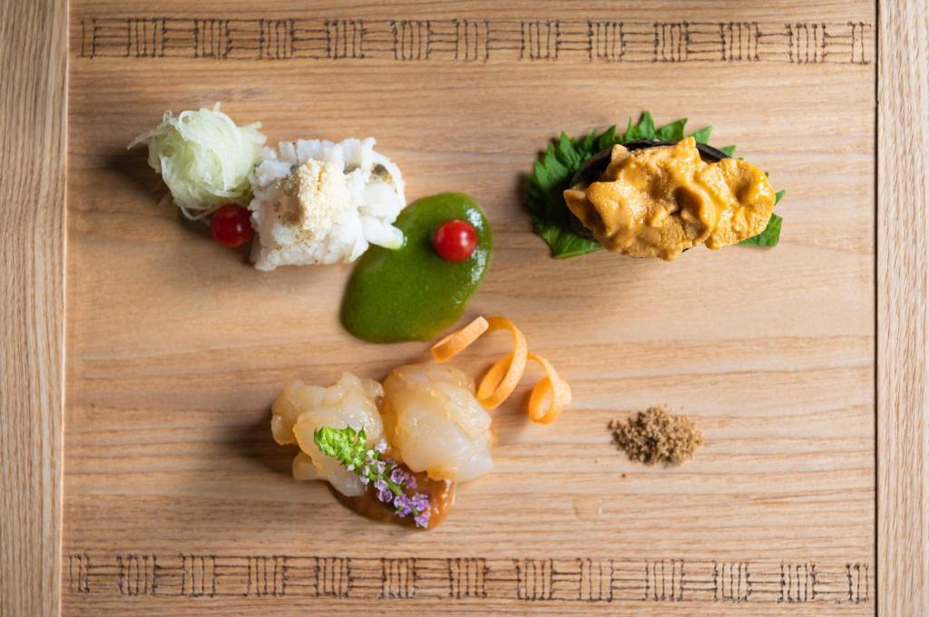 un plateau de découpe en bois recouvert de différents types de denrées alimentaires dans l'établissement Arimasansoh Goshobessho, à Kobe
