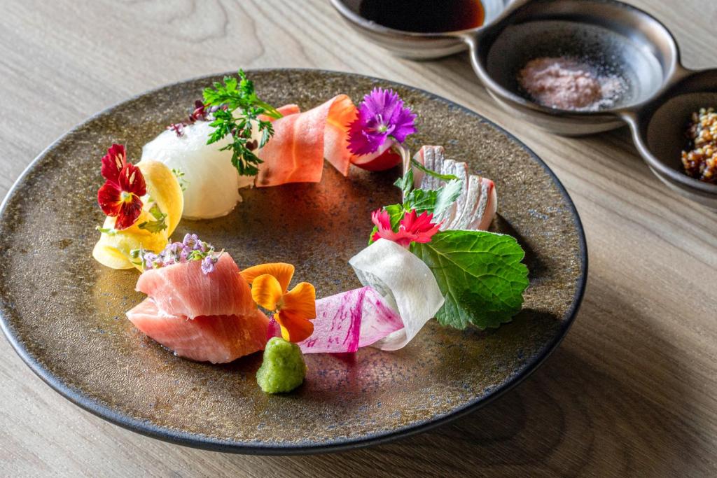 une assiette de nourriture avec des sushis sur une table dans l'établissement Urakusatsu TOU, à Kusatsu