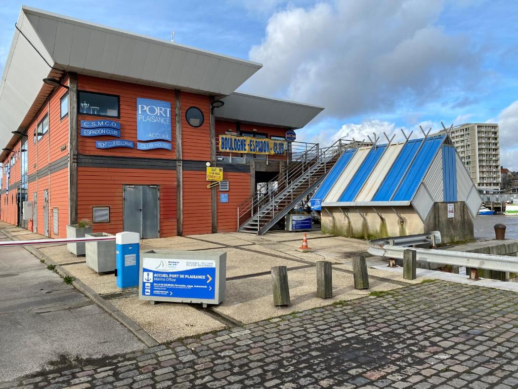 un bâtiment avec une enseigne devant lui dans l'établissement Nuit insolite à bord du bateau Exocet III, à Boulogne-sur-Mer