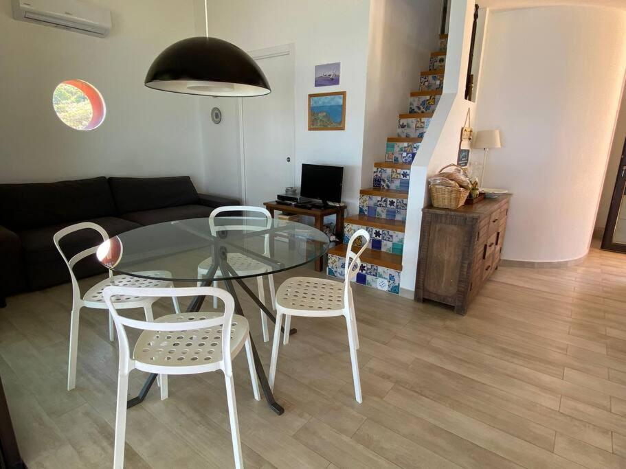 - une table et des chaises en verre dans le salon dans l'établissement Cefalu - luxury seaview villa x10, à Cefalù