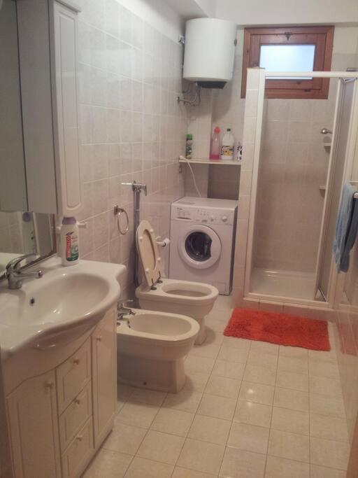 La salle de bains est pourvue d'un lavabo, de toilettes et d'un lave-linge. dans l'établissement Villa Pino with exclusive private pool only 50m from the beach, à Campobello di Mazara