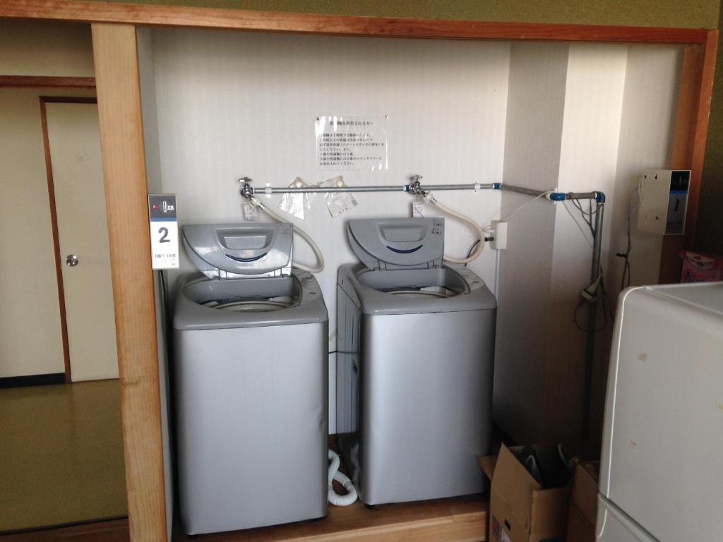 deux lave-linge installés côte à côte dans une pièce dans l'établissement Hotel Tetora Yunokawaonsen, à Hakodate